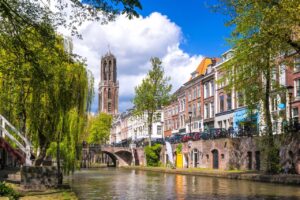 Utrechtse gracht met grachtenpanden aan weerszijden en de Domtoren in de achtergrond.